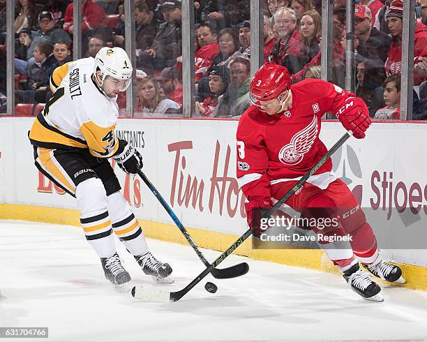 Justin Schultz of the Pittsburgh Penguins battles for the puck with Nick Jensen of the Detroit Red Wings during an NHL game at Joe Louis Arena on...