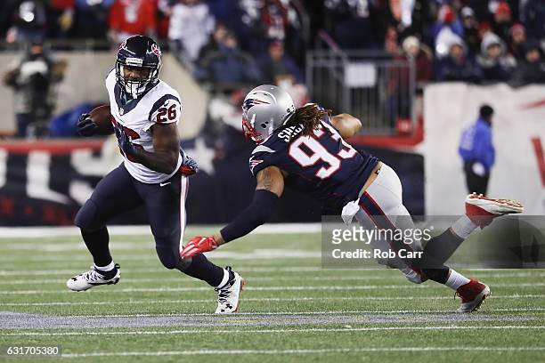 Lamar Miller of the Houston Texans evades a tackle by Jabaal Sheard of the New England Patriots in the first half during the AFC Divisional Playoff...