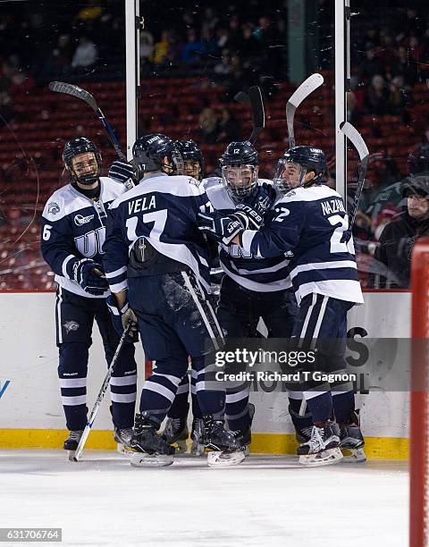 Shane Eiserman of the New Hampshire Wildcats celebrates his goal against the Northeastern Huskies with his teammates Ara Nazarian, Marcus Vela,...