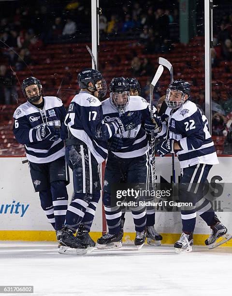 Shane Eiserman of the New Hampshire Wildcats celebrates his goal against the Northeastern Huskies with his teammates Ara Nazarian, Marcus Vela,...