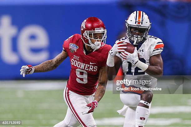 Auburn Tigers wide receiver Eli Stove catches a pass against Oklahoma Sooners linebacker Tay Evans during the game between the Auburn Tigers and the...