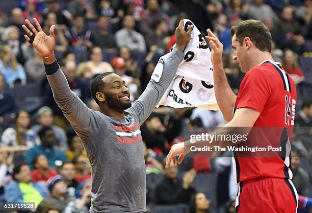 Washington Wizards guard John Wall greets Jason Smith after he nailed a late game three pointer against the Philadelphia 76ers at the Verizon Center...