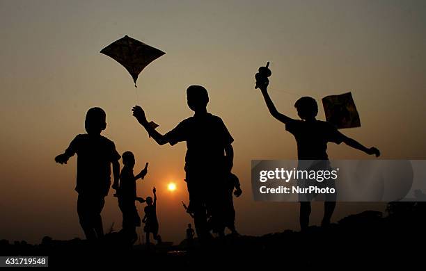 Village living children are flying kites as they are playing together on the banks of holy river Daya before day out just outskirts of the eastern...