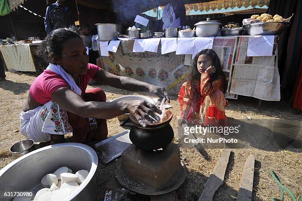 Nepalese Tharu community woman preparing traditional Tharu food during the Maghi festival celebrations, or the New Year of the Tharu community at...