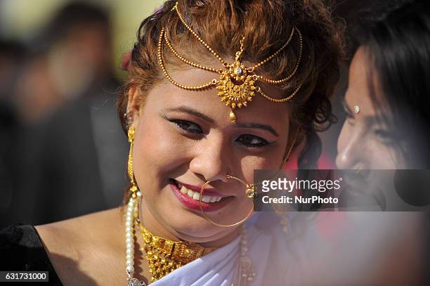 Portrait of Nepalese Tharu community girl smiles in a traditional attire during prade of the Maghi festival celebrations, or the New Year of the...