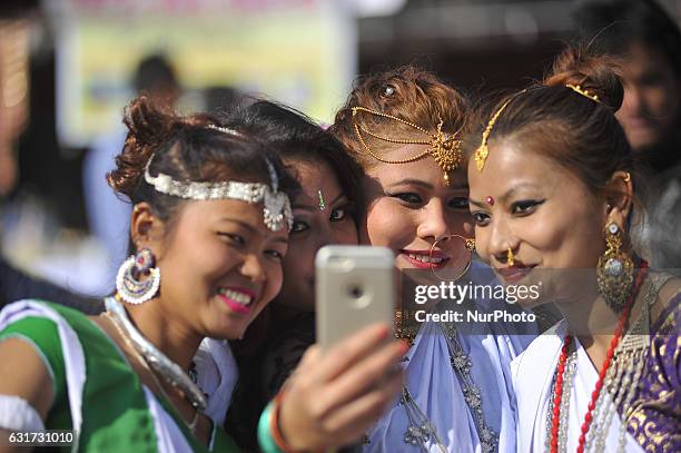 Nepalese Tharu community girls takes selfie in a traditional attire during prade of the Maghi festival celebrations, or the New Year of the Tharu...