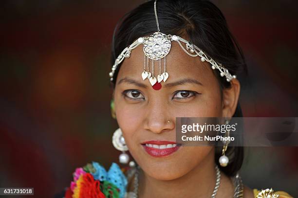 Portrait of Nepalese Tharu community girl in a traditional attire during prade of the Maghi festival celebrations, or the New Year of the Tharu...