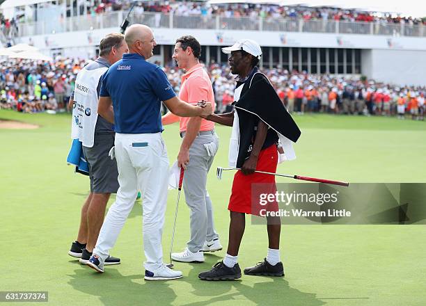 Graeme Storm of England is congratulated by his caddie Jeffrey Wkonyane on the 18th green after beating Rory McIlroy of Northern Ireland in the third...