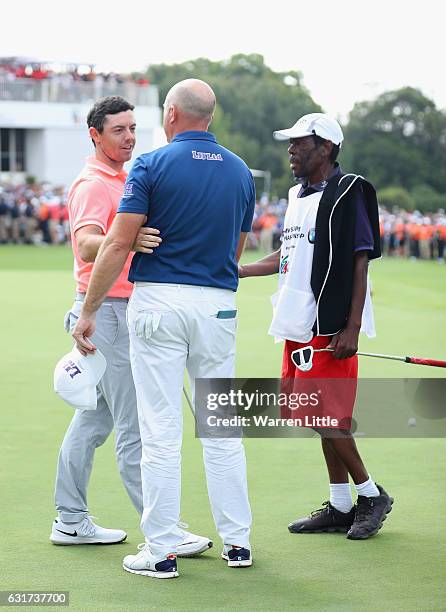 Rory McIlroy of Northern Ireland congratulates Graeme Storm of England after victory in the third extra play off hole during the final round of the...