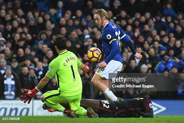 Tom Davies of Everton lifts the ball over goalkeeper Claudio Bravo of Manchester City to score his team's third goal during the Premier League match...