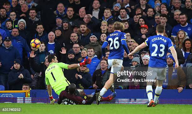 Tom Davies of Everton lifts the ball over goalkeeper Claudio Bravo of Manchester City to score his team's third goal during the Premier League match...