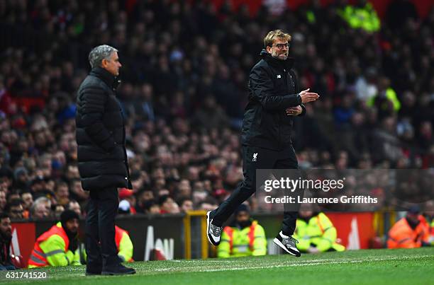 Jurgen Klopp manager of Liverpool reacts as Jose Mourinho manager of Manchester United looks on during the Premier League match between Manchester...