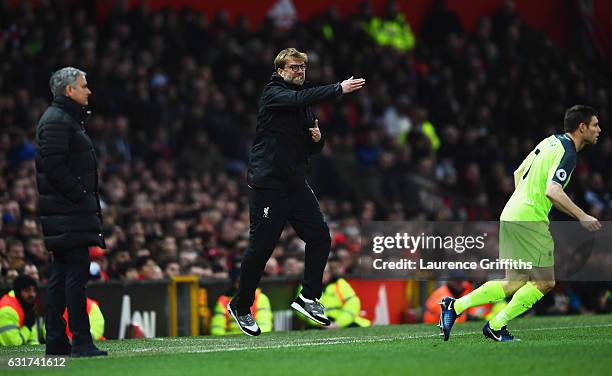 Jurgen Klopp manager of Liverpool reacts as Jose Mourinho manager of Manchester United looks on during the Premier League match between Manchester...