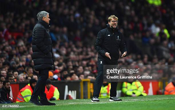 Jurgen Klopp manager of Liverpool reacts as Jose Mourinho manager of Manchester United looks on during the Premier League match between Manchester...