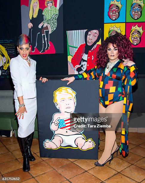 Personality/Pop artist Sham Ibrahim and performer INeedARose pose for a photo with a Donald Trump portrait at Oscar's on January 14, 2017 in Palm...