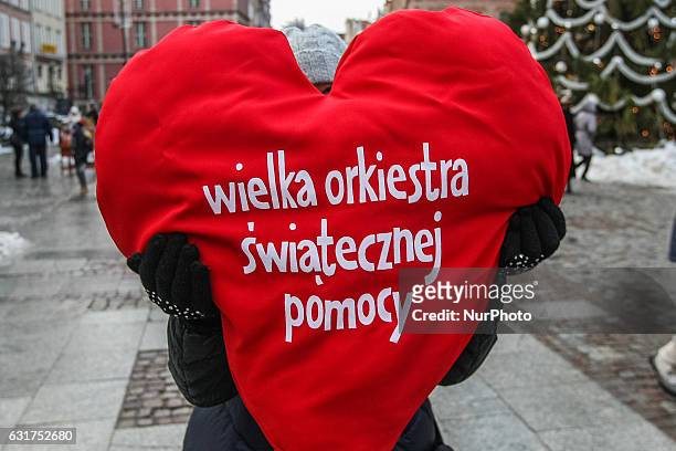 Woman with big red heart pillow - WOSP logo is seen during 25th Grand Finale of Great Orchestra of Christmas Charity on January 15th, 2017 in Gdansk....