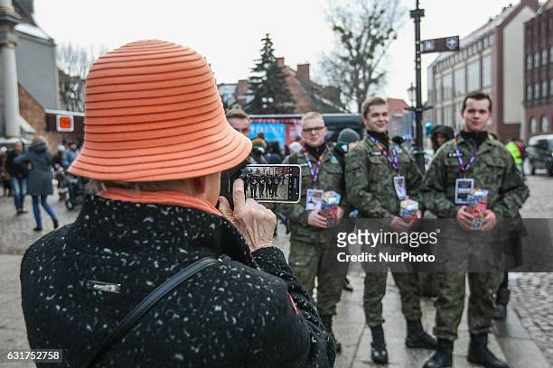 Woman taking a picture of volunteers collecting money is seen during 25th Grand Finale of Great Orchestra of Christmas Charity on January 15th, 2017...