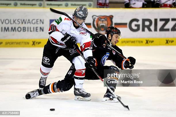 Alexander Weiss of Wolfsburg and Christian Ehrhoff of Koeln battle for the puck during the DEL match between Grizzly Wolfsburg and Koelner Haie at...