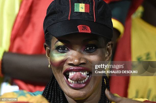 Senegal supporter sticks her tongue out during the 2017 Africa Cup of Nations group B football match between Tunisia and Senegal in Franceville on...