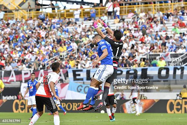 River Plate goalkeeper Augusto Batalla goes over Millonarios defender Andres Felipe Cadavid Cardona to take away a cross during the first half of a...