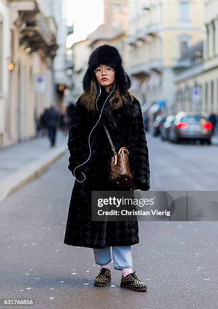 Song Yuxi is wearing a checked coat, fur hat, Louis Vuitton bag during Milan Men's Fashion Week Fall/Winter 2017/18 on January 15, 2017 in Milan,...