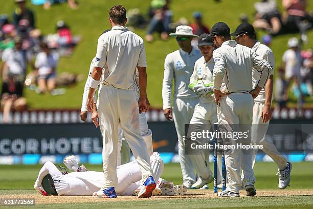 Players check on the welfare of Mushfiqur Rahim of Bangladesh after being struck in the helmet by a Tim Southee delivery during day five of the First...