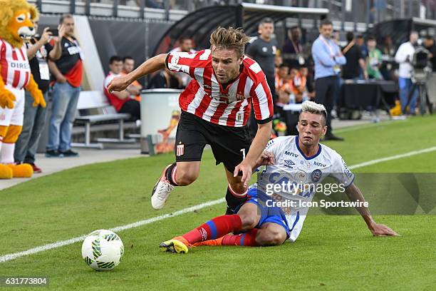Estudiantes defender Facundo Sanchez has the ball tackled by Bahia midfielder Paulo Junior during the first half of the Florida Cup game between...