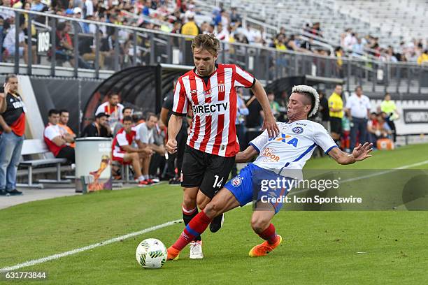 Estudiantes defender Facundo Sanchez has the ball tackled by Bahia midfielder Paulo Junior during the first half of the Florida Cup game between...