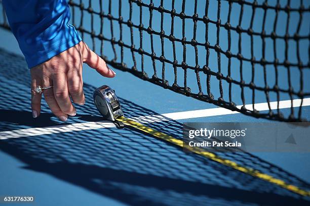 An umpire measures the net details ahead of the first round match between Varvara Lepchenko of the United States and Kiki Berterns of the Netherlands...