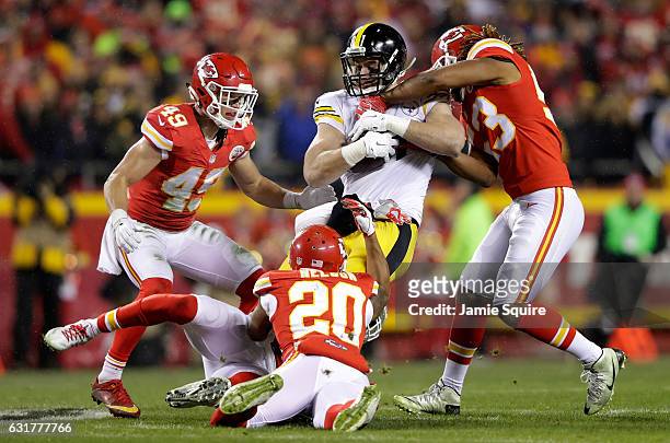 Tight end Jesse James of the Pittsburgh Steelers is tackled inside linebacker Ramik Wilson of the Kansas City Chiefs and teammates Steven Nelson and...