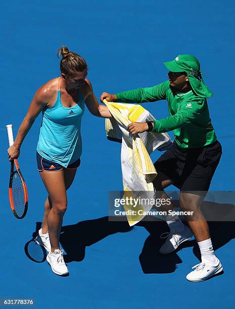 Simona Halep of Romania takes her towel from the ball boy during her first round match against Shelby Rogers of the USA on day one of the 2017...