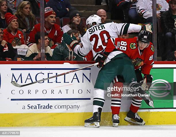 Patrick Kane of the Chicago Blackhawks gets tangled up with Ryan Suter of the Minnesota Wild along the boards at the United Center on January 15,...