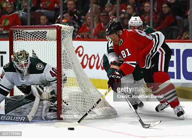 Marian Hossa of the Chicago Blackhawks tries to get off a shot at Devan Dubnyk of the Minnesota Wild as Mikko Koivu defends at the United Center on...