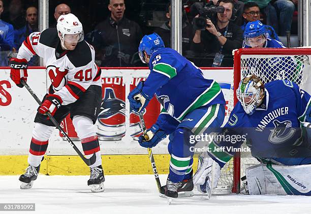 Bruce Coleman of the New Jersey Devils shoots past Alex Biega as he scores on Jacob Markstrom of the Vancouver Canucks during their NHL game at...