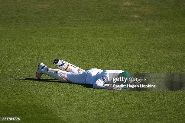 Sabbir Rahman of Bangladesh lies on the ground after a missed fielding opportunity during day five of the First Test match between New Zealand and...