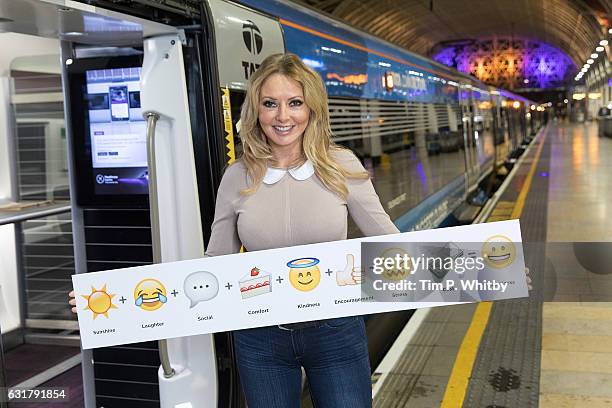 Carol Vorderman poses for a photo with a formula for happiness, expressed in emojis to help cheer passengers on 'Blue Monday' and to highlight the...