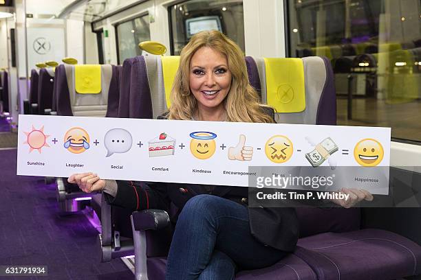 Carol Vorderman poses for a photo with a formula for happiness, expressed in emojis to help cheer passengers on 'Blue Monday' and to highlight the...