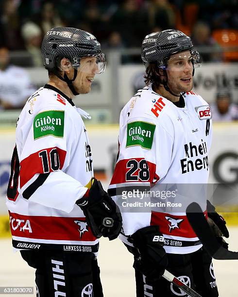 Christian Ehrhoff of Koeln talks to team mate Ryan Jones during the DEL match between Grizzly Wolfsburg and Koelner Haie at BraWo Ice Arena on...