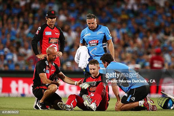 Peter Nevill of the Melbourne Renegades is helped by medical staff and players after he was hit by the bat of Brad Hodge of the Adelaide Strikers...