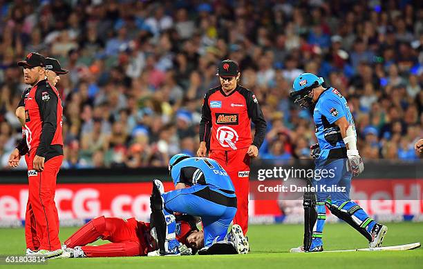 Peter Nevill of the Melbourne Renegades lays on the ground after being struck in the head by the bat of Brad Hodge of the Adelaide Strikers as Jono...