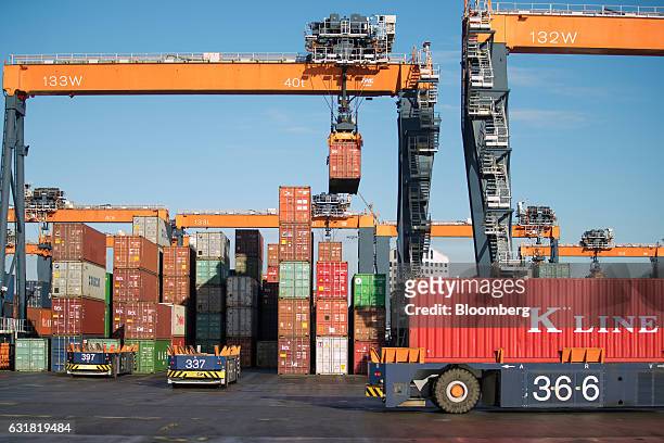 An automated guided vehicle transports a K Line shipping container on the dockside as gantry cranes operate at the Euromax terminal, operated by...