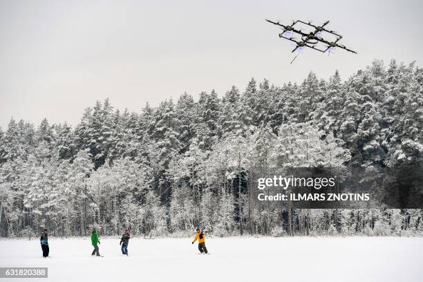 Snowboarders are pulled by sixteen propeller drone on Niniera lake surface near Cesis, Latvia, on January 14, 2017.