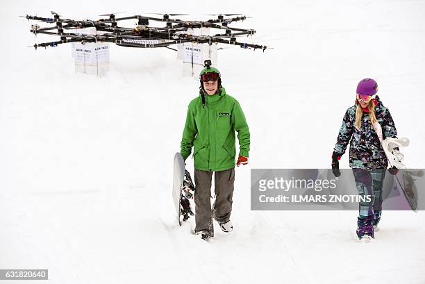 Davis Ceize and Anita Leina walk after droneboarding on Niniera lake surface near Cesis, Latvia, on January 14, 2017. / AFP / afp / Ilmars ZNOTINS