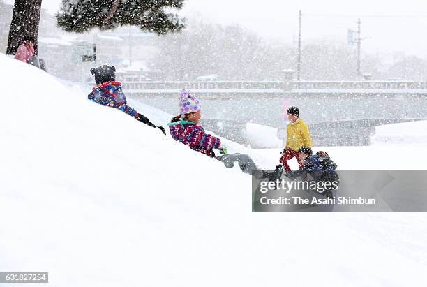 Children play with snow at a river bank of Kamogawa River as snow falls in wider area on January 15, 2017 in Kyoto, Japan. The Meteorological Agency...