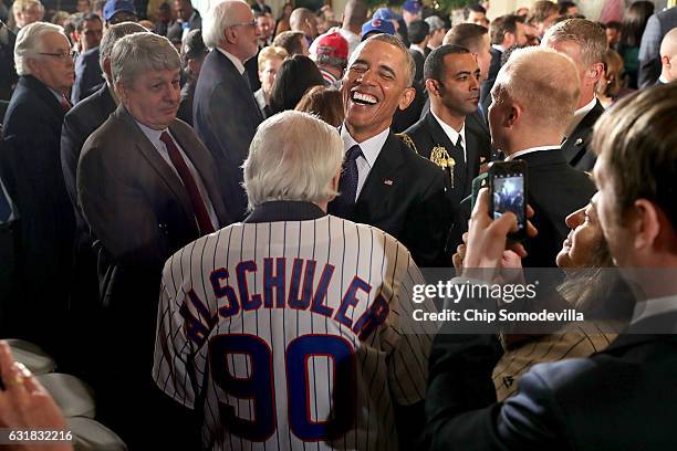 President Barack Obama shares a laugh with Chicago Cubs fan Frank Alschuler while celebrating the team's World Series championship in the East Room...