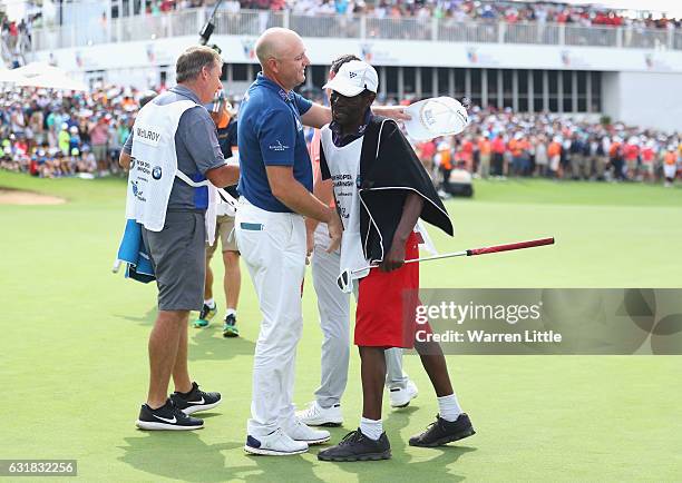 Graeme Storm of England is congratulated by his caddie Jeffrey Wkonyane on the 18th green after beating Rory McIlroy of Northern Ireland in the third...