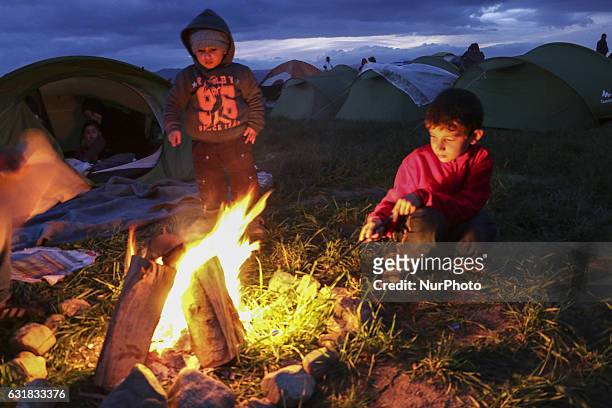Refugees and migrants try to warm themselves through fires in the makeshift camp in Idomeni, Greece February 2016. They use everything to sustain the...