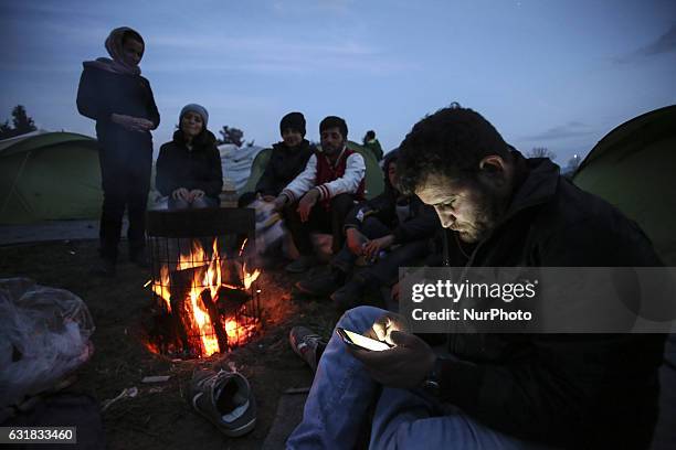 Refugees and migrants try to warm themselves through fires in the makeshift camp in Idomeni, Greece February 2016. They use everything to sustain the...