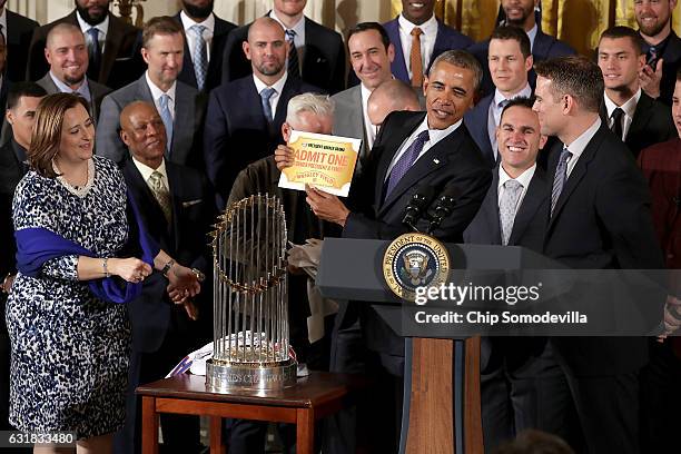 President Barack Obama holds up his lifetime ticket given to him by Major League Baseball World Series champion Chicago Cubs co-owner Laura Ricketts...