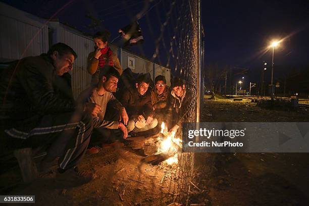 Refugees and migrants try to warm themselves through fires in the makeshift camp in Idomeni, Greece February 2016. They use everything to sustain the...